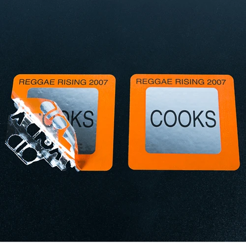 Silver square tamper-evident ‘ownership’ label with orange and black ink and the checkerboard residue pattern