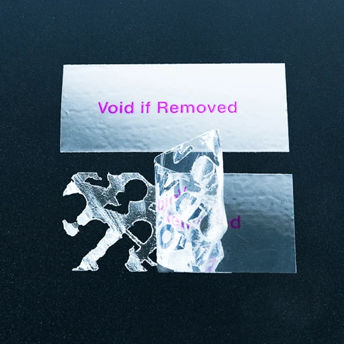 Silver rectangular warning label with squared corners and VOID residue pattern