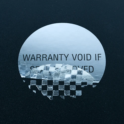 Circular silver warranty warning label with checkerboard residue pattern